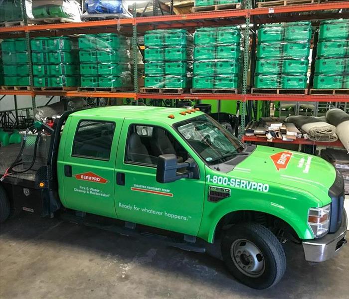 Green SERVPRO truck in warehouse.