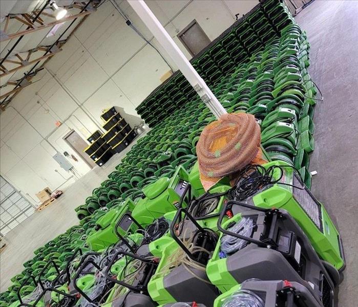 Multiple pieces of Green SERVPRO water restoration equipment in a warehouse ready for dispatch